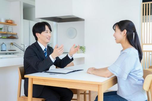リビングで女性と商談をするビジネスマン リビングで女性と商談をするビジネスマン 営業,金融,保険の写真素材