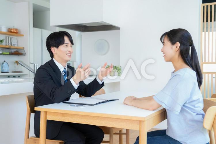 リビングで女性と商談をするビジネスマン 営業,金融,保険の写真素材