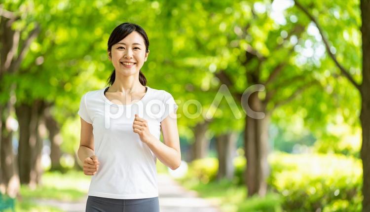 夏の公園でジョギングする若い日本人女性 女性,ジョギング,ランニングの写真素材