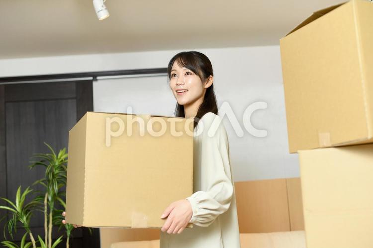 段ボールを運ぶ笑顔のアジア人の女性 女性,引っ越し,新生活の写真素材