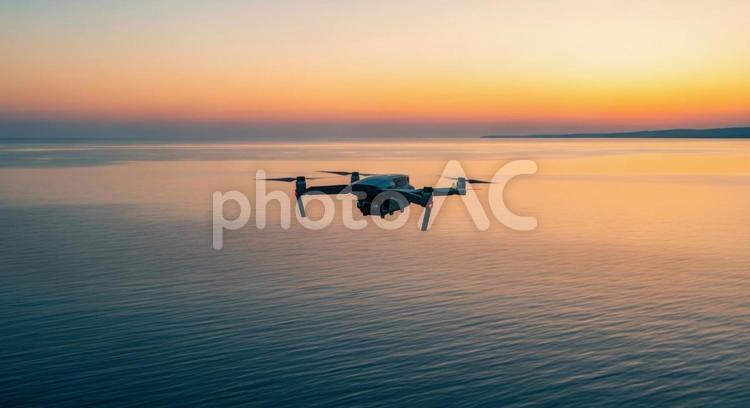 ドローンが夕暮れの海の上を飛行する風景 ドローン,空撮,夕焼けの写真素材