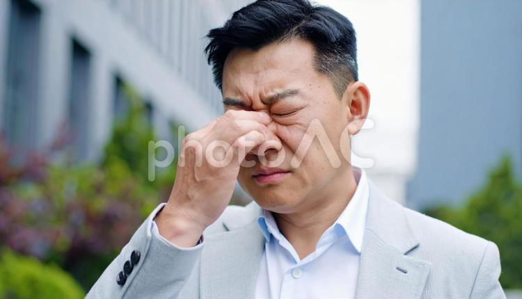 目を擦っている中年男性 アレルギー,花粉症,過労の写真素材