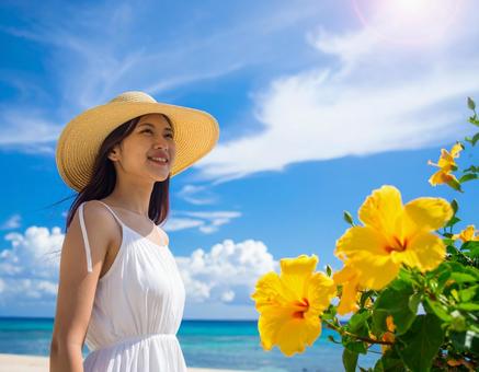 夏旅の彼女・夏空と黄色いハイビスカスの写真