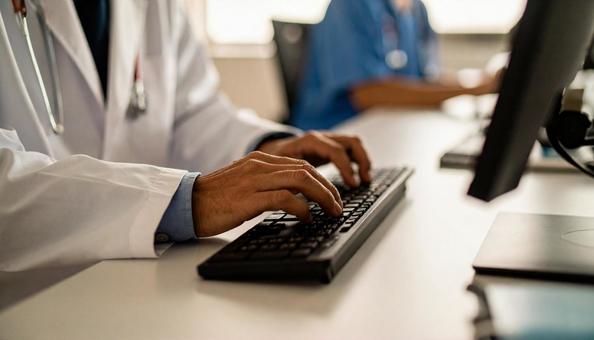 病院で電子カルテに入力する男性の手もと 病院で電子カルテに入力する男性の手もとの写真