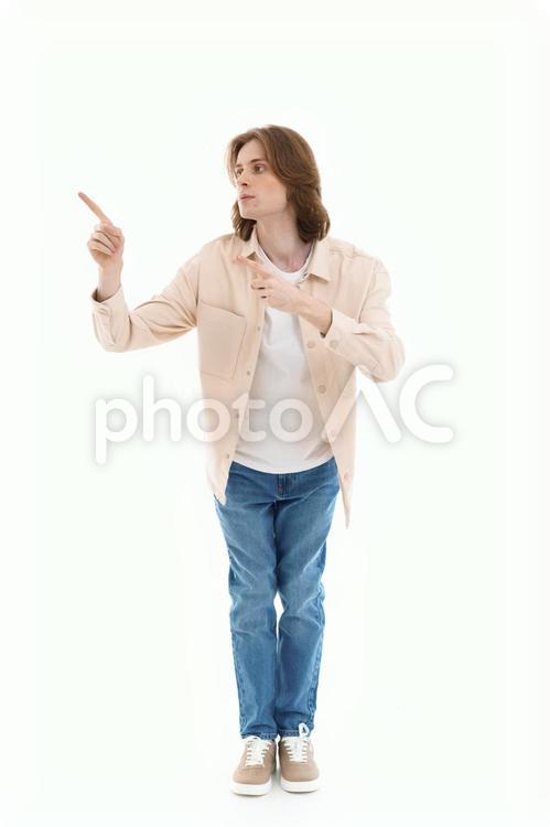 屈んで両手で指差しする男性 男性,指差し,ポーズの写真素材