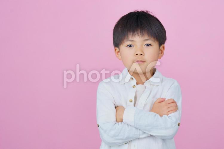 ピンクのカラー背景に腕を組んだ男の子 男の子,男児,腕を組むの写真素材
