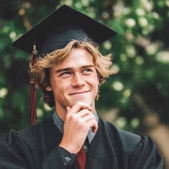 卒業帽をかぶり、未来を思い描く少年の写真