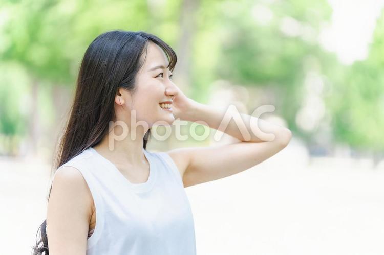 新緑の中で髪を触る笑顔の日本人女性 ヘアケア,女性,シャンプーの写真素材