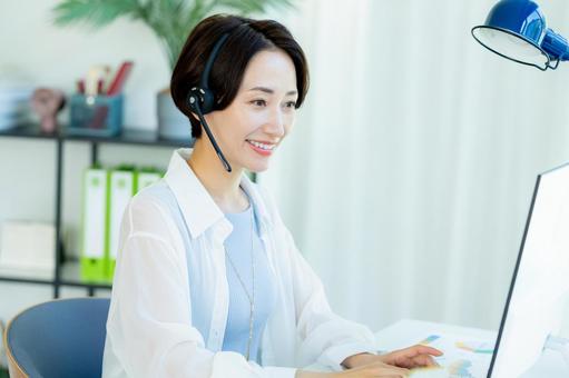 オフィスで働く女性のオペレーター オフィスで働く女性のオペレーター オペレーター,女性,笑顔の写真素材