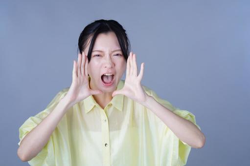 大声で呼ぶ黄色い服の女性 女性,叫ぶ,応援の写真素材