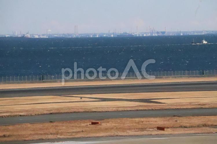滑走路と海と対岸の工場地帯と空の風景 滑走路,海,対岸の写真素材
