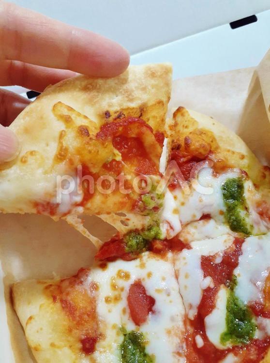 宅配ピザ＊マルゲリータを食べる＊女性の手 ピザ,宅配ピザ,マルゲリータの写真素材