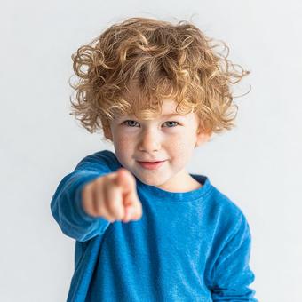 笑顔でこちらを指差す活発な少年 笑顔でこちらを指差す活発な少年の写真