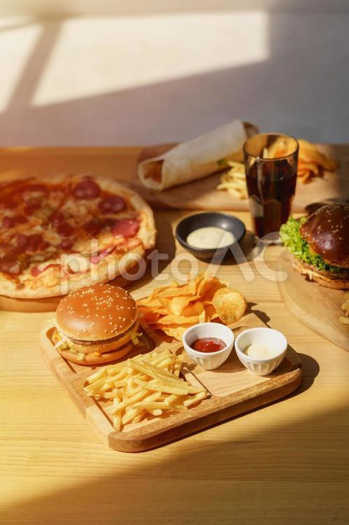 ピザとハンバーガーとブリトーなどと太陽 ハンバーガー,ピザ,ナチョスの写真素材