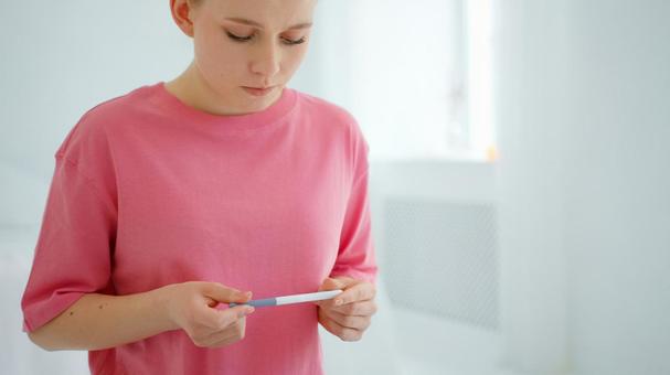 真剣な顔で検査薬を見る女性 真剣な顔で検査薬を見る女性の写真