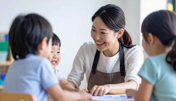 保育園で子供と遊ぶ笑顔の保育士の女性 保育園で子供と遊ぶ笑顔の保育士の女性の写真