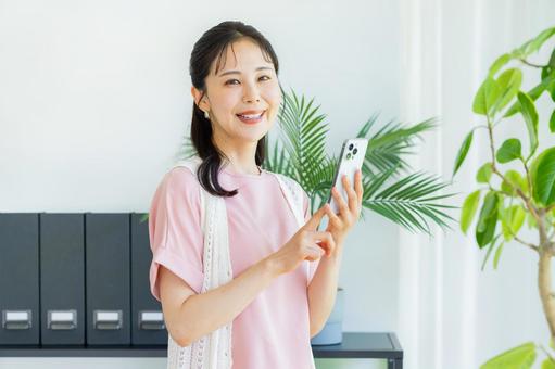 スマホを操作する女性 スマホを操作する女性の写真