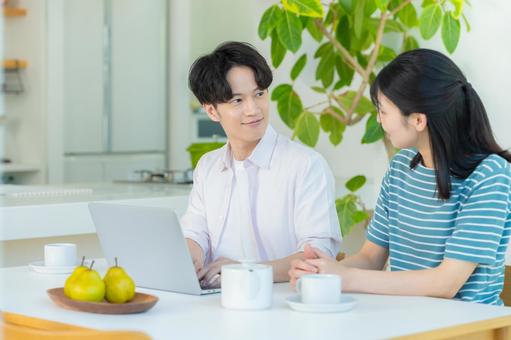 パソコンを見るカップル ノートパソコン,笑顔,カップルの写真素材