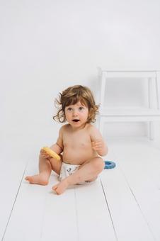 玩具を持ち座る笑顔の赤ちゃん 玩具を持ち座る笑顔の赤ちゃん 赤ちゃん,かわいい,お座りの写真素材
