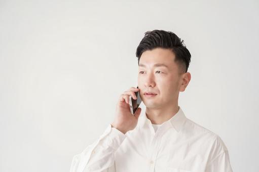 スマートフォンで通話する男性 スマートフォンで通話する男性 ビジネスマン,男性,30代の写真素材