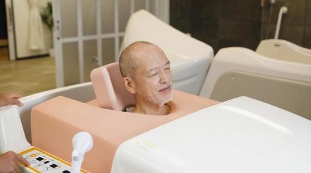 機械浴で入浴介助を受けるアジア人高齢者 高齢者,機械浴,入浴の写真素材