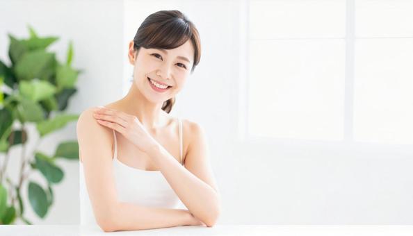 笑顔の女性がスキンケアする朝のワンシーン 笑顔の女性がスキンケアする朝のワンシーンの写真