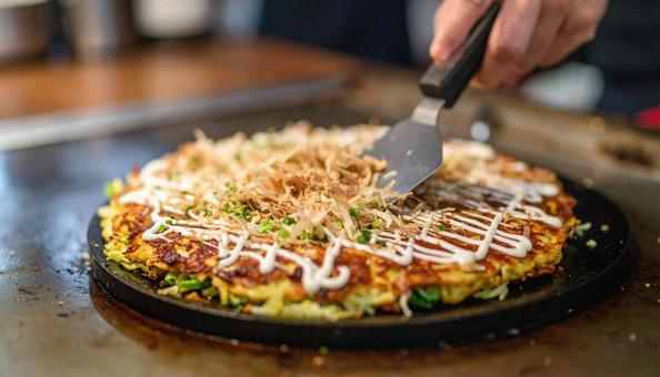 お好み焼きを鉄板で焼く お好み焼きを鉄板で焼くの写真
