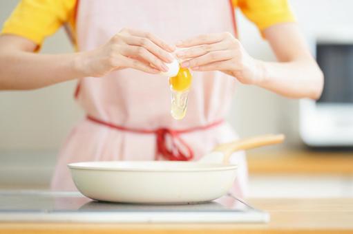 卵を割る両手の写真