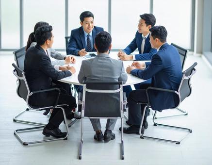 ビジネス会議を行うスーツ姿の男性たち ビジネス会議を行うスーツ姿の男性たちの写真