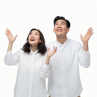 驚きと喜びで上を見上げる二人 驚きと喜びで上を見上げる二人の写真