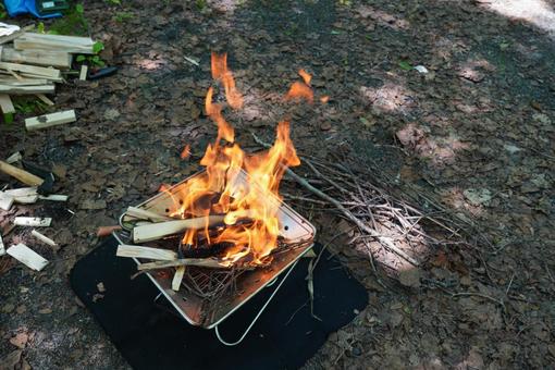 森のなかで焚き火の写真