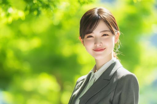 深緑を背景に笑顔の女性会社員 深緑を背景に笑顔の女性会社員の写真