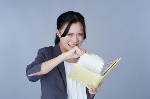 グレーの服の女性が黄色い本を破る 女性,破る,イライラの写真素材