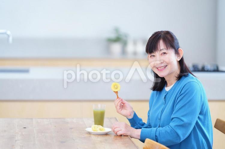 キウイとスムージーを楽しむ女性 主婦,家政婦,シニアの写真素材