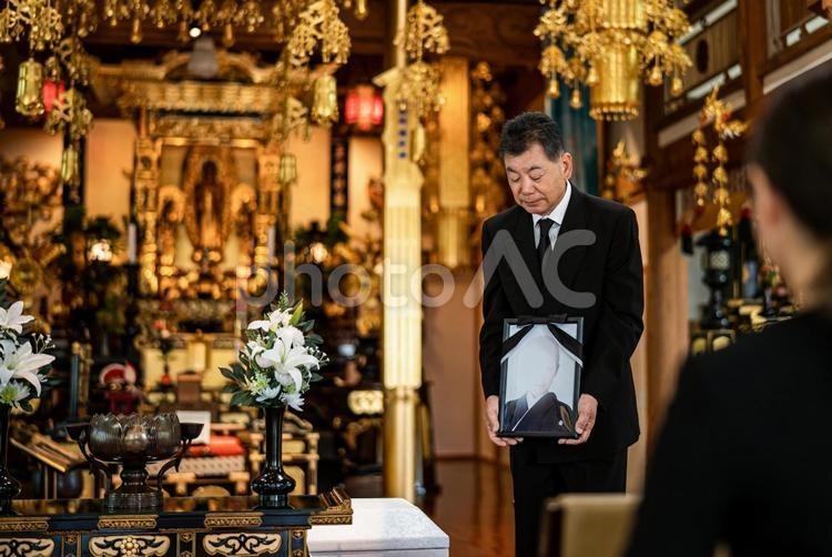 お葬式で挨拶する高齢者男性（喪主の挨拶） 喪主,葬儀,遺影の写真素材