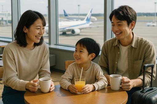 空港のカフェで出発を待つ若い夫婦と子ども 空港のカフェで出発を待つ若い夫婦と子どもの写真