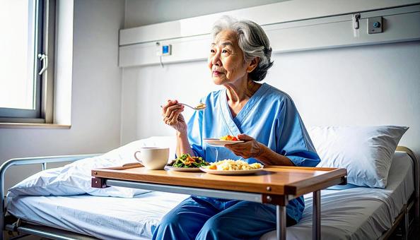 座って食事をするシニア女性の患者 座って食事をするシニア女性の患者の写真