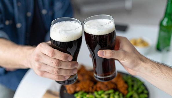 ビールで乾杯する二人の男性の手 ビールで乾杯する二人の男性の手の写真