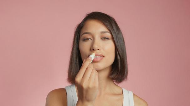女性がリップクリームを塗っている 女性がリップクリームを塗っている 女性,外国人,アジア人の写真素材
