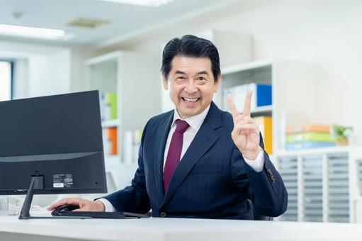 オフィスで喜ぶビジネスマン オフィスで喜ぶビジネスマンの写真