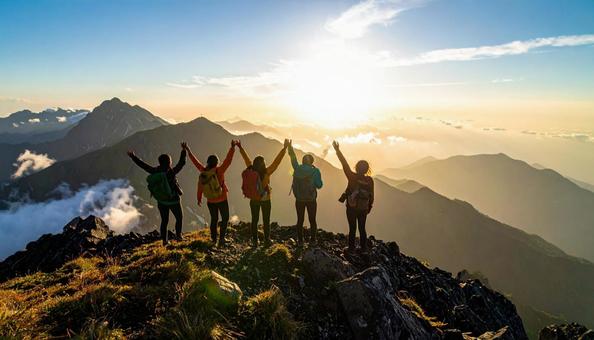 夏山で朝日に向かって手をあげる登山者 夏山で朝日に向かって手をあげる登山者の写真