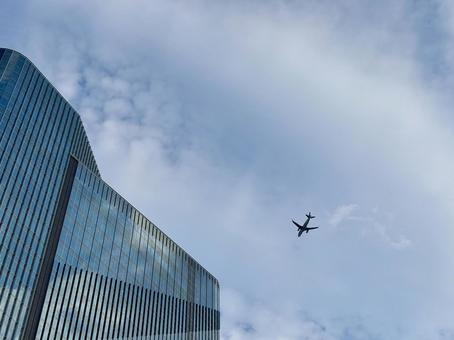 ビルと飛行機 ビルと飛行機 飛行機,雲,文字スペースの写真素材