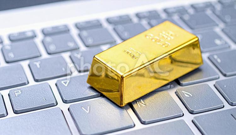 パソコンに置かれた金の延べ棒のミニチュア 金,ゴールド,先物の写真素材