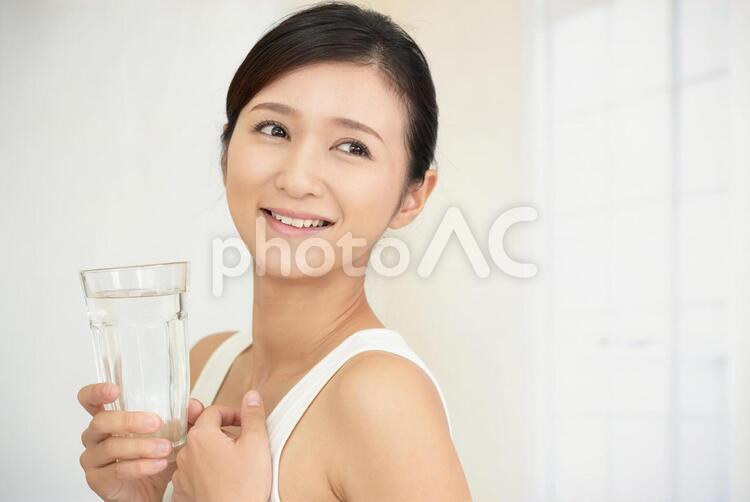お水の入ったグラスを持つ笑顔の女性 女性,女,笑顔の写真素材