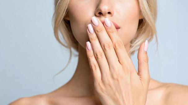 口を手で覆う西洋人女性01の写真