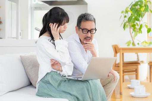 リビングでパソコンを見るミドルの夫婦 リビングでパソコンを見るミドルの夫婦 夫婦,家族,ミドルの写真素材