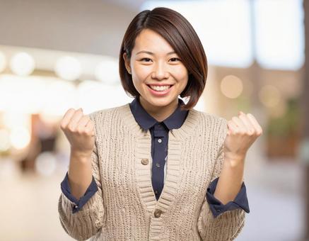 ガッツポーズで喜ぶ若い女性 ガッツポーズで喜ぶ若い女性の写真