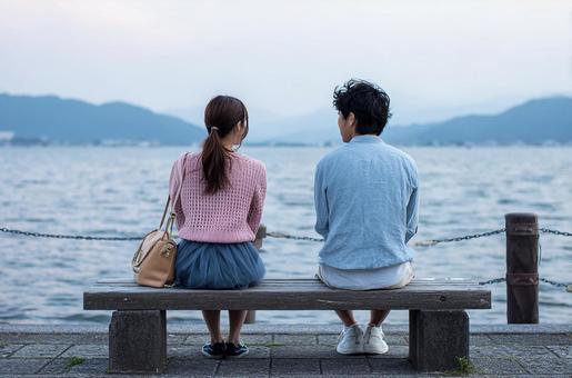 水辺のベンチで語り合う二人 水辺のベンチで語り合う二人の写真