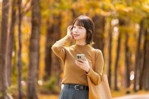 紅葉の街路樹と女性・ビジネスウーマン 女性,秋,紅葉の写真素材