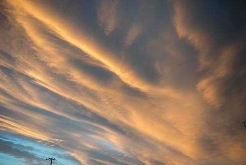 電線と夕日に照らされた雲 電線と夕日に照らされた雲の写真
